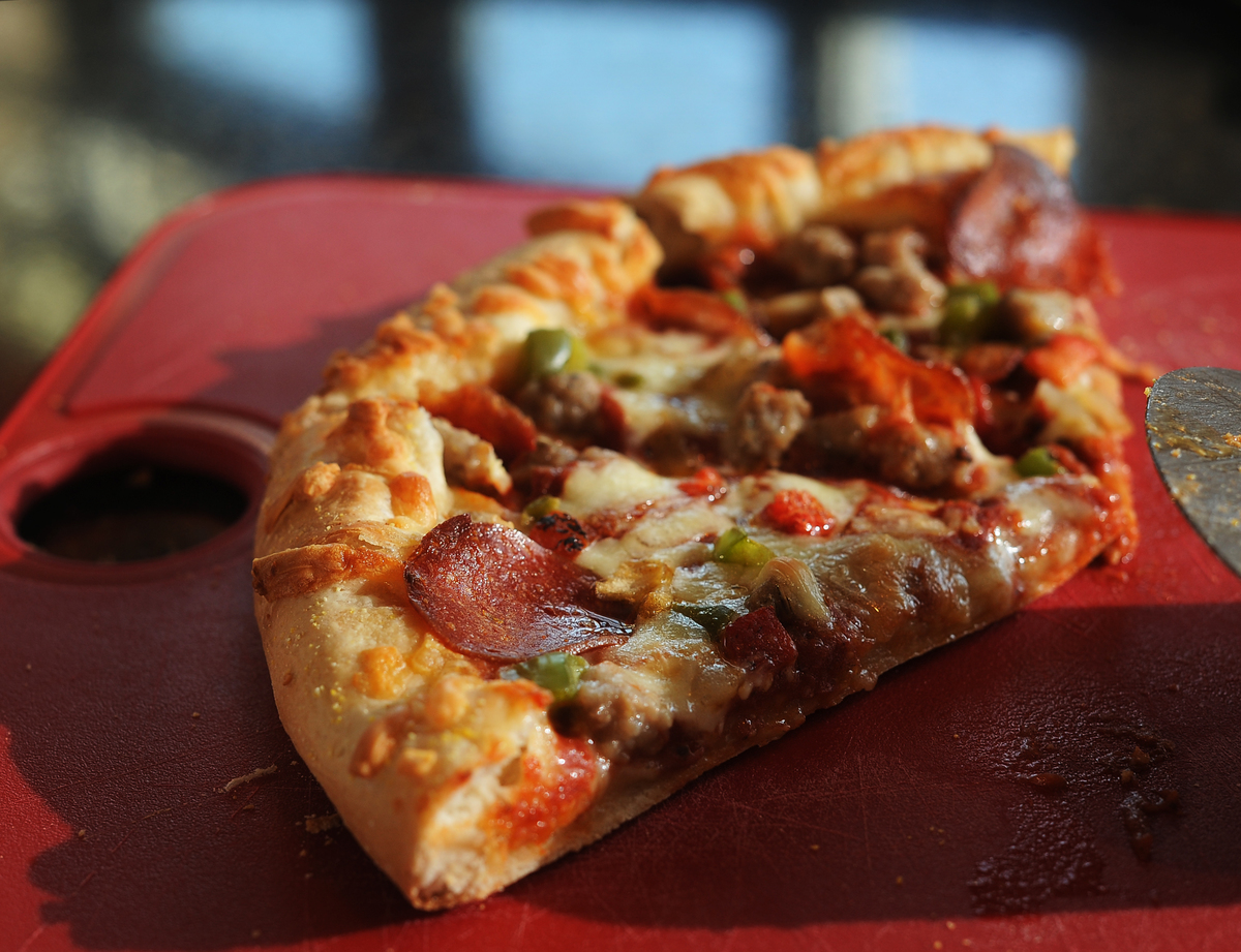 Annie's organic frozen pizza is cooked and lies on a cutting board.