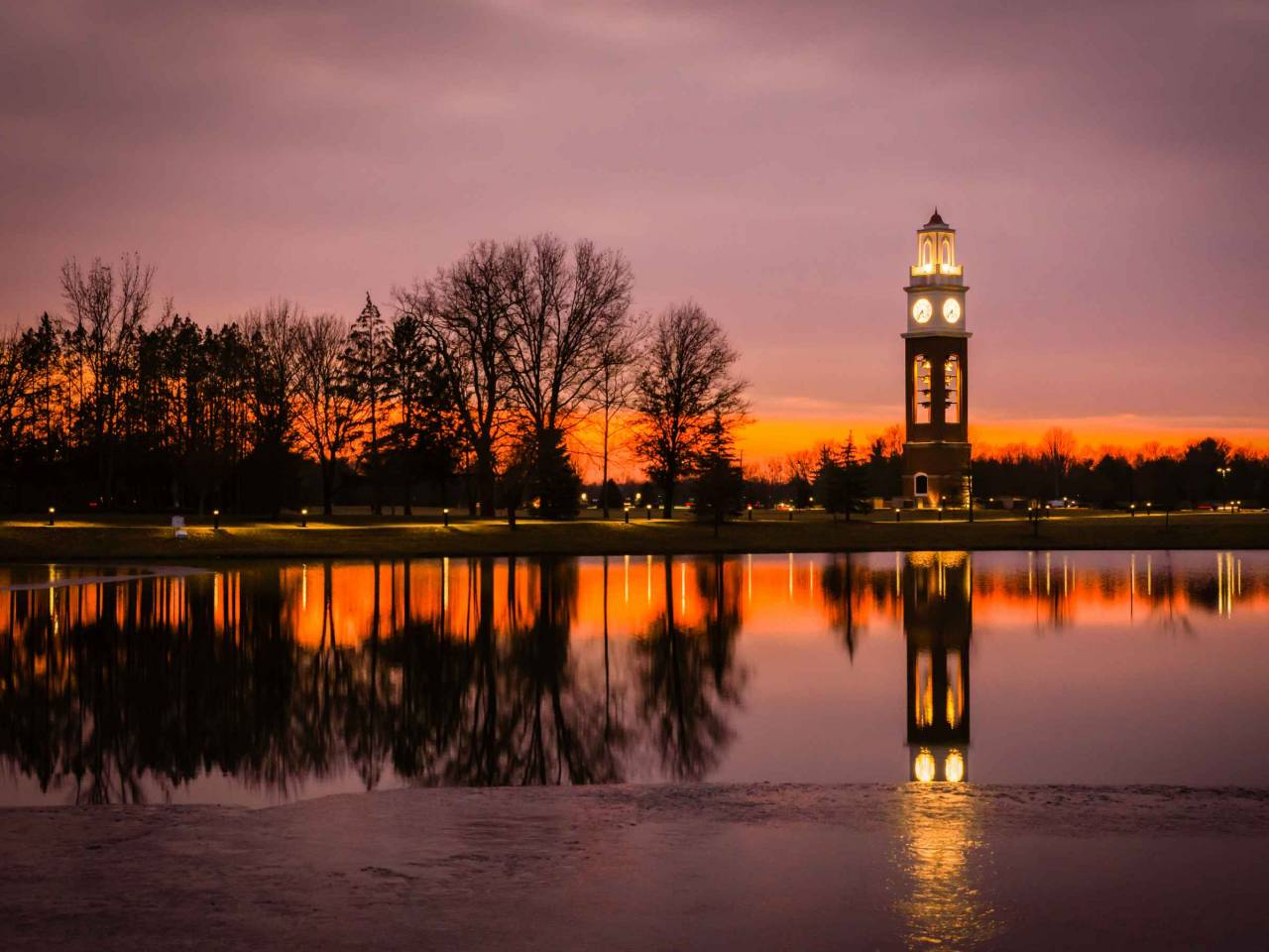 Bell tower and lake at Coxhall Garden in Carmel Indiana at sunset in the winter of 2019